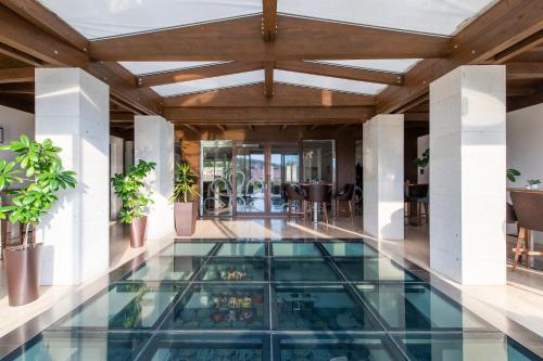 马德Botrytis Borhotel的一座带玻璃地板的室内游泳池