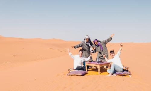 MhamidMhamid camp activités的一群人坐在沙漠里