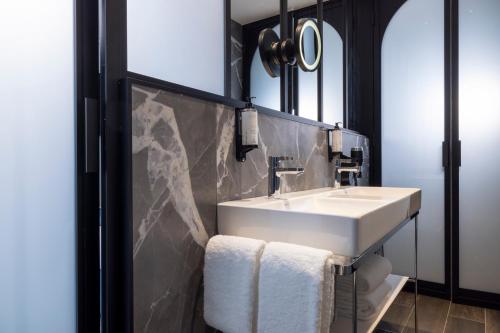 巴黎法兰西车站里昂巴士底狱酒店的浴室设有白色水槽和镜子