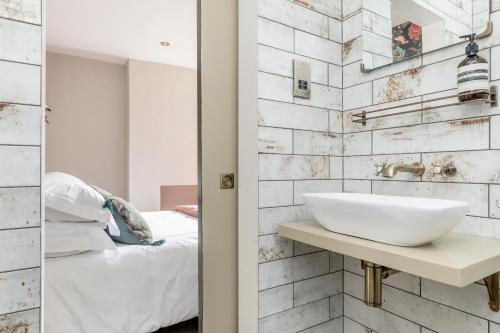 HurstpierpointThe Oak Rooms - Stylish & luxurious stay in Sussex by Huluki Sussex Stays的一间带白色水槽的浴室和一间卧室