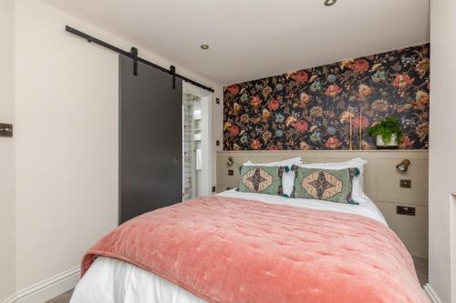 HurstpierpointThe Oak Rooms - Stylish & luxurious stay in Sussex by Huluki Sussex Stays的一间卧室设有一张带花卉墙壁的大床