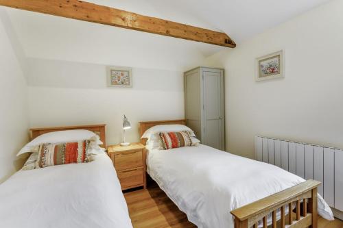 维斯贝希Woodpecker Barn - Uk38613的配有白色墙壁和木地板的客房内的两张床