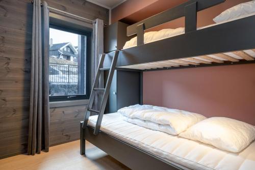 贝特斯托尔Riddertunet apartment 101的一间卧室设有两张双层床和一扇窗户。