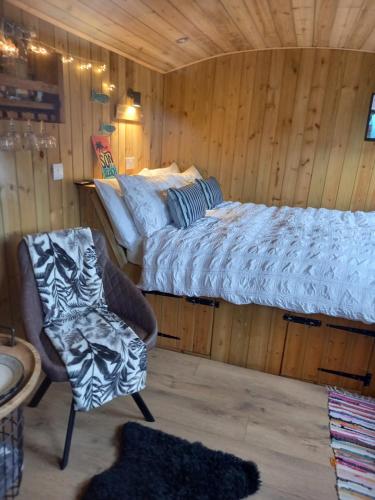 圣艾夫斯Stargazy Shepherds Hut的一间卧室,卧室内配有一张床和一把椅子