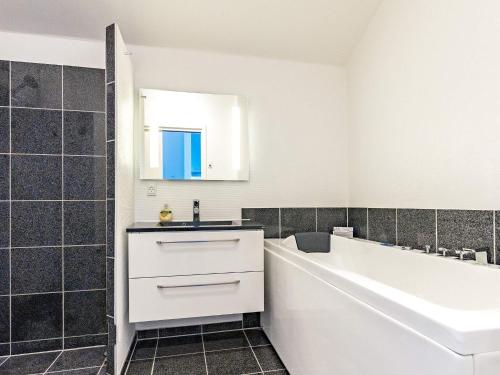 博恩瑟4 person holiday home in Bogense的白色的浴室设有水槽和浴缸。