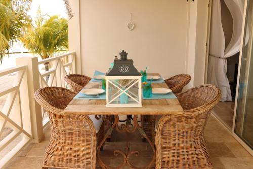克拉伦代克Caribbean Lofts Bonaire的餐桌、藤椅和台灯