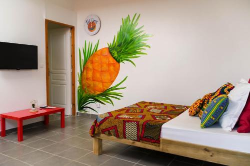 勒拉芒坦Bel'oasis的一间设有一张床铺的房间,墙上挂着 ⁇ 萝