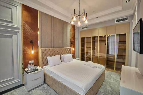 撒马尔罕Continental Hotel Samarkand的卧室配有一张白色大床和吊灯。