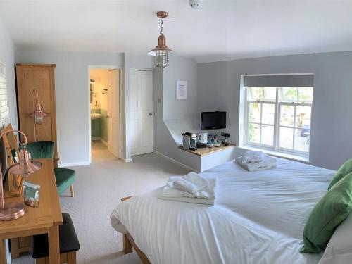 MoulsfordFerryman`s Cottage at The Beetle & Wedge的一间卧室配有一张床,上面有两条毛巾