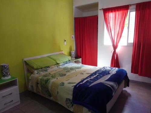 圣何塞La casa de Norma的一间卧室配有床和红色窗帘的窗户