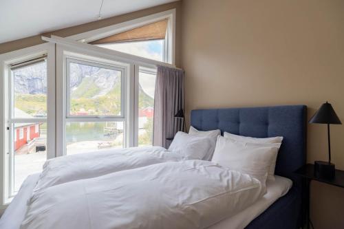 雷讷May's Apartments by May's的一间卧室配有一张带蓝色床头板的床和窗户