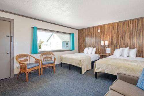 大洋城Beach Bum Inn的酒店客房带两张床和一张桌子以及椅子。
