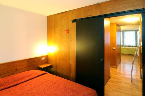 佛加里达米提洛罗索公寓的一间卧室配有一张带黑色门的床
