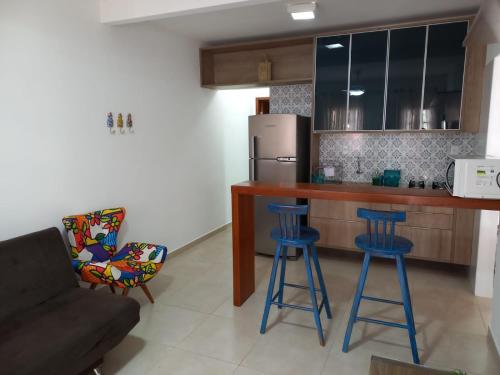 伦索伊斯Lindo Apartamento em Lençóis的厨房配有蓝色酒吧凳和冰箱