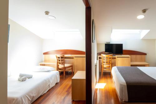 费罗尔Real Ferrol的酒店客房设有两张床、一张书桌和电视