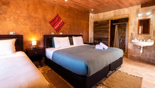 圣佩德罗·德·阿塔卡马Foresta Atacama Lodge的一间卧室配有两张床和水槽