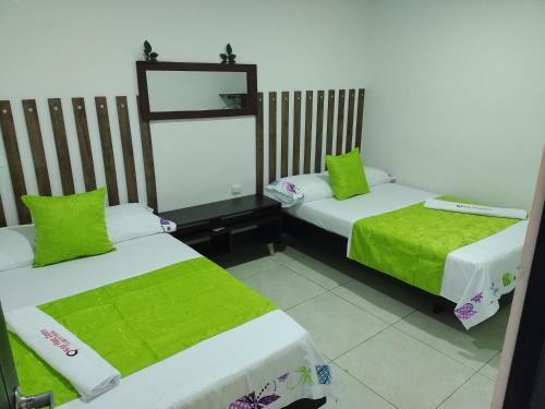 弗洛伦西亚Hotel plaza centro的客房 - 带两张带绿床单的床
