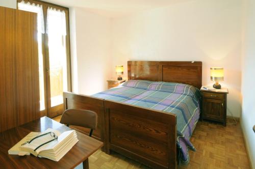 CrovianaCasa Anselmi的一间卧室配有一张带书桌的床和一张带书籍的桌子。