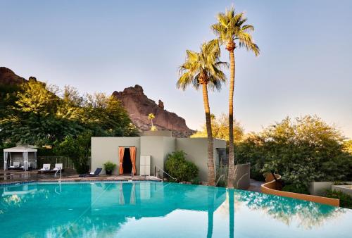 斯科茨Sanctuary Camelback Mountain, A Gurney's Resort and Spa的一座棕榈树游泳池和一座房子