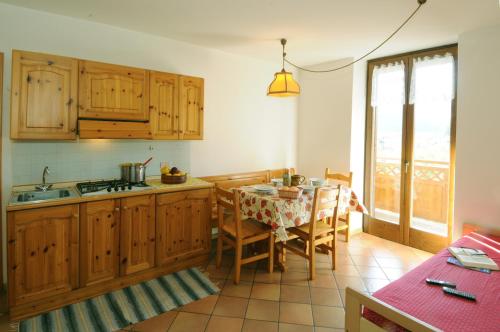 CrovianaCasa Anselmi的厨房配有木制橱柜和桌椅