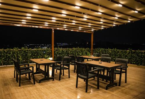 伊斯坦布尔Hotel Orkide的一群桌子和椅子在晚上在庭院里