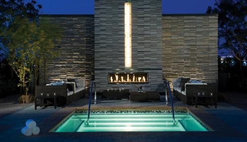 拉斯维加斯StripViewSuites Two-Bedroom Con-Joined Exclusive Condo的一座砖砌建筑前的游泳池,设有壁炉