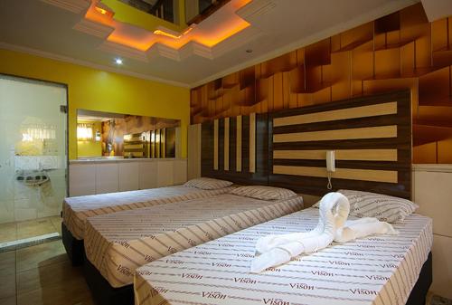 瓜鲁柳斯Motel Vison (Próximo GRU Aeroporto)的配有两张床的旅馆客房