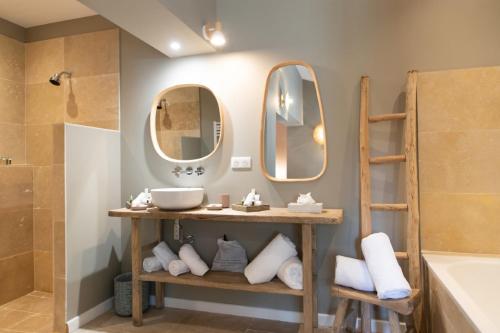 圣特罗佩拉巴斯蒂德安托万酒店的浴室设有两面镜子、一个水槽和一个浴缸。