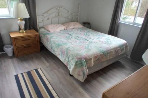 柏斯海滩2 Bedroom Condo in Rehoboth Beach w/ New Bed的一间卧室配有一张床和一个带灯的床头柜