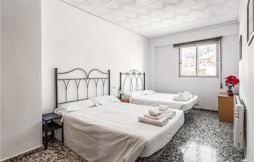 卡马雷纳德拉谢拉Pet Friendly Apartment In Camarena De La Sierra With Wifi的一间白色卧室,配有两张床和窗户