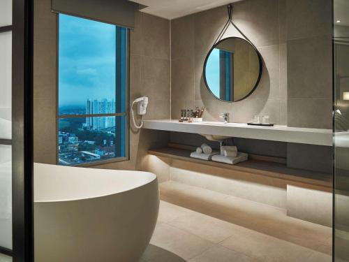 加拉旺光大大酒店 的带浴缸和镜子的浴室