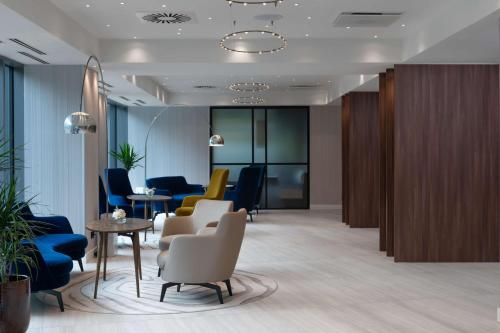 克卢日-纳波卡Radisson Blu Hotel, Cluj的大堂设有带桌椅的等候室
