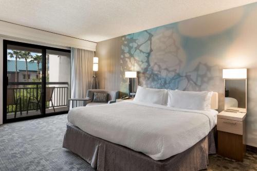 坦培Sonesta Select Tempe Downtown的酒店客房设有一张大床和一个阳台。