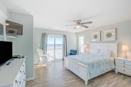 托普赛尔海滩Avalon Topsail Beach的一间白色卧室,配有床和阳台