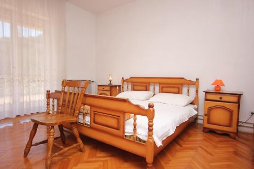 ZaglavApartments by the sea Zaglav, Dugi otok - 8146的一间卧室配有木床和木椅