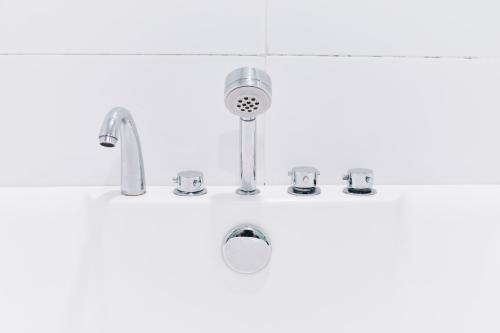 瓜拉丁加奴J套房酒店的带淋浴和水龙头的盥洗盆的浴室