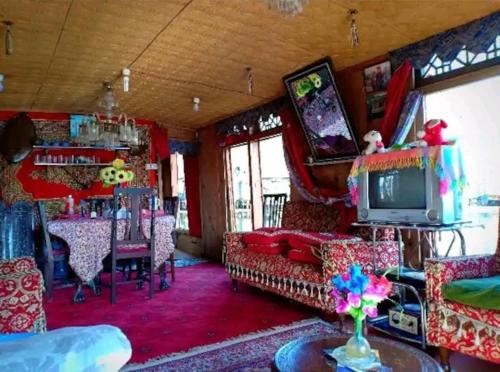 斯利那加H.B.victoria Garden的客厅配有家具和电视。