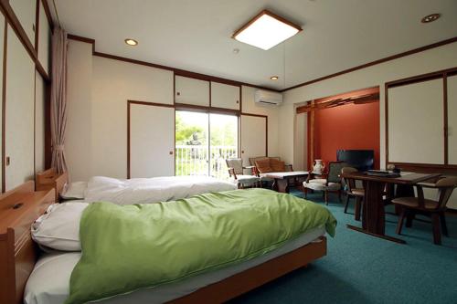 旭川高砂温泉日式旅馆的卧室配有一张床和一张桌子及椅子