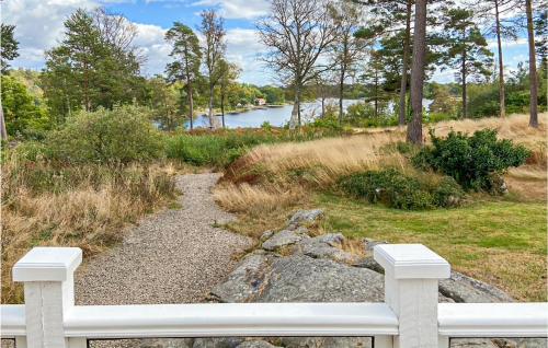 龙讷比Stunning Home In Ronneby With House Sea View的坐在河前的白色长凳