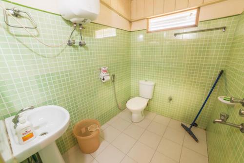 RinchingpongYangsum Heritage Farm的绿色瓷砖浴室设有水槽和卫生间