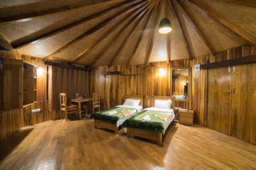 RinchingpongYangsum Heritage Farm的一间设有两张床的房间和一张帐篷内的桌子