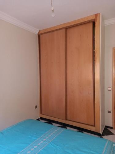 卡萨布兰卡APPARTEMENT ZENITH的配有一张床的房间里设有一个大型木制衣柜