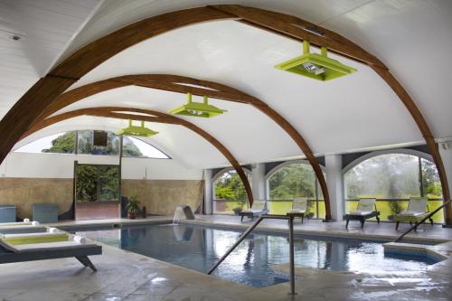 Scavino唐华金旅游乡村民宿的一个带拱形天花板的室内游泳池和一个大型游泳池
