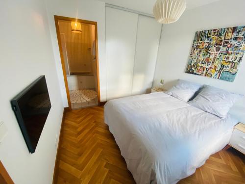拉罗谢尔Appartement Saint Claude - Centre Port的卧室配有白色的床和电视。