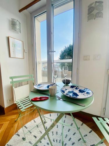 拉罗谢尔Appartement Saint Claude - Centre Port的一张绿桌,上面有两个盘子和玻璃杯