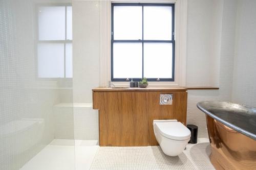 伦敦Liverpool St Three Bedroom Home near Tube Station的浴室配有卫生间、盥洗盆和浴缸。
