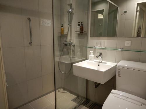 广岛Smile Hotel Hiroshima的带淋浴、盥洗盆和卫生间的浴室