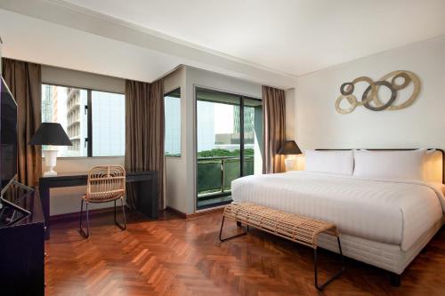 雅加达Oakwood Suites Kuningan Jakarta的一间卧室设有一张大床和一个大窗户