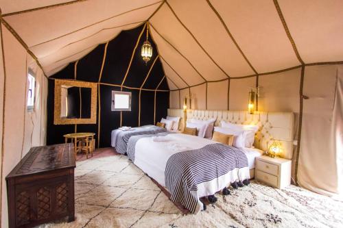 姆哈米德Luxury Camp desert Maroc Tours的一间帐篷内带两张床的卧室