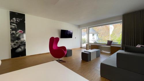 科赫姆Moselfreude的客厅配有红色椅子和沙发